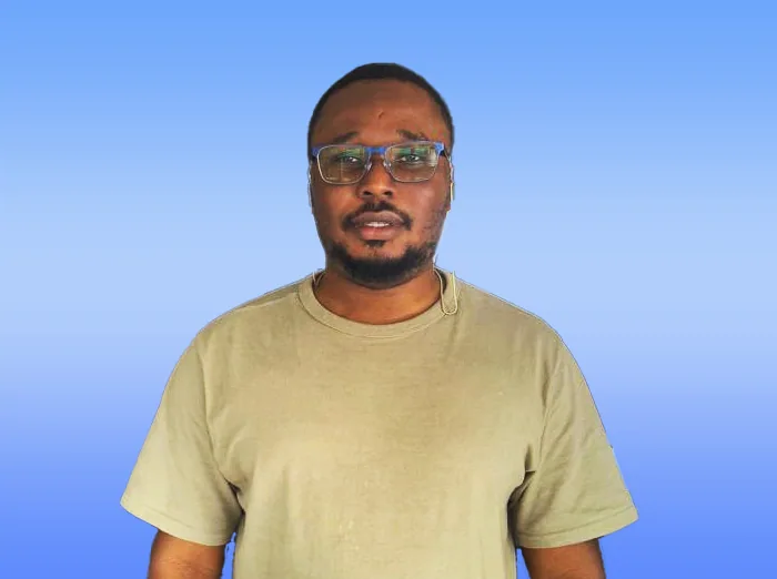 Olaniyi Oluwasegun Ishola wearing glasses and a beige T-shirt against a blue background