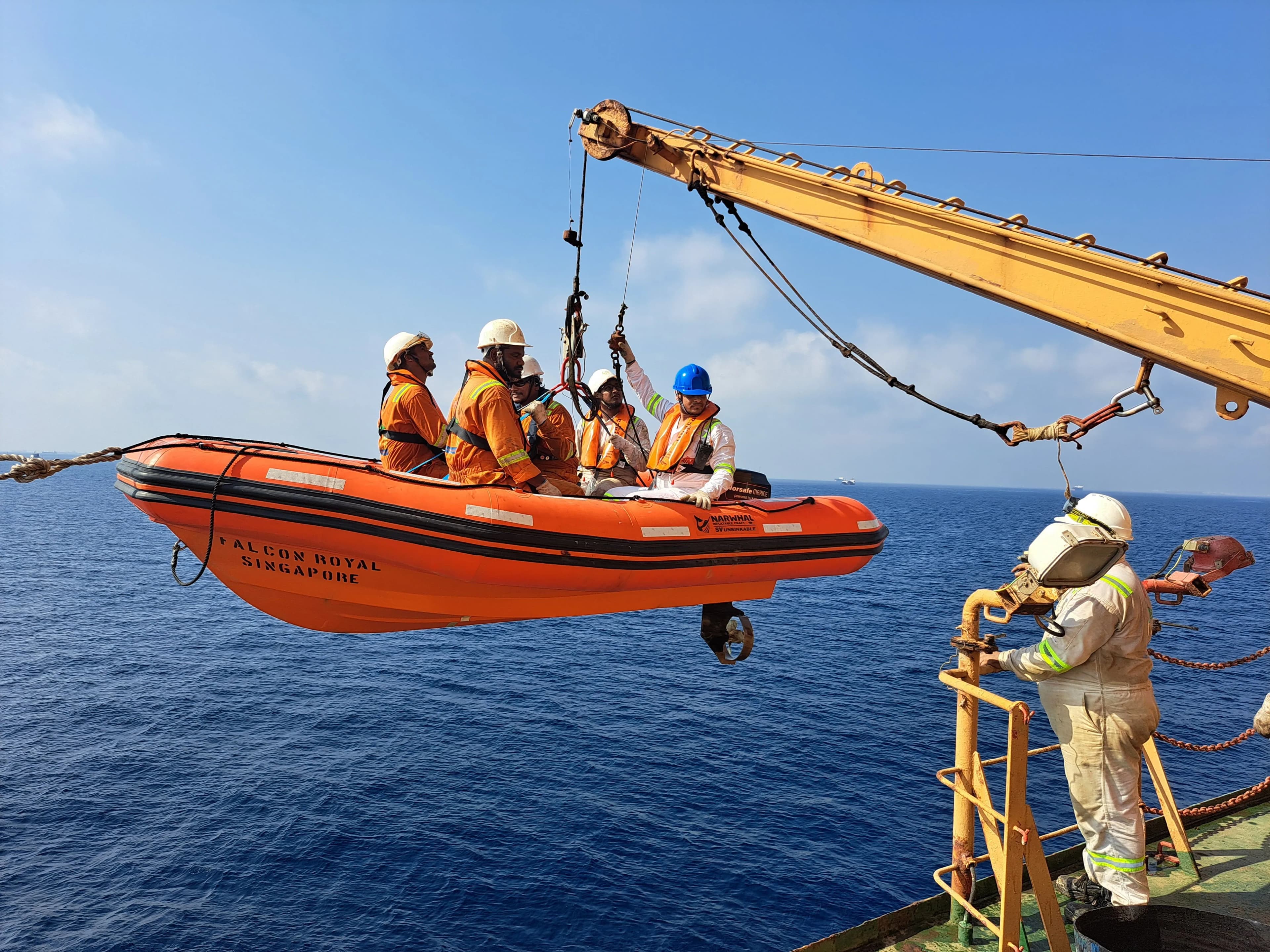 Offshore personnel in safety equipment transferring by workboat at sea