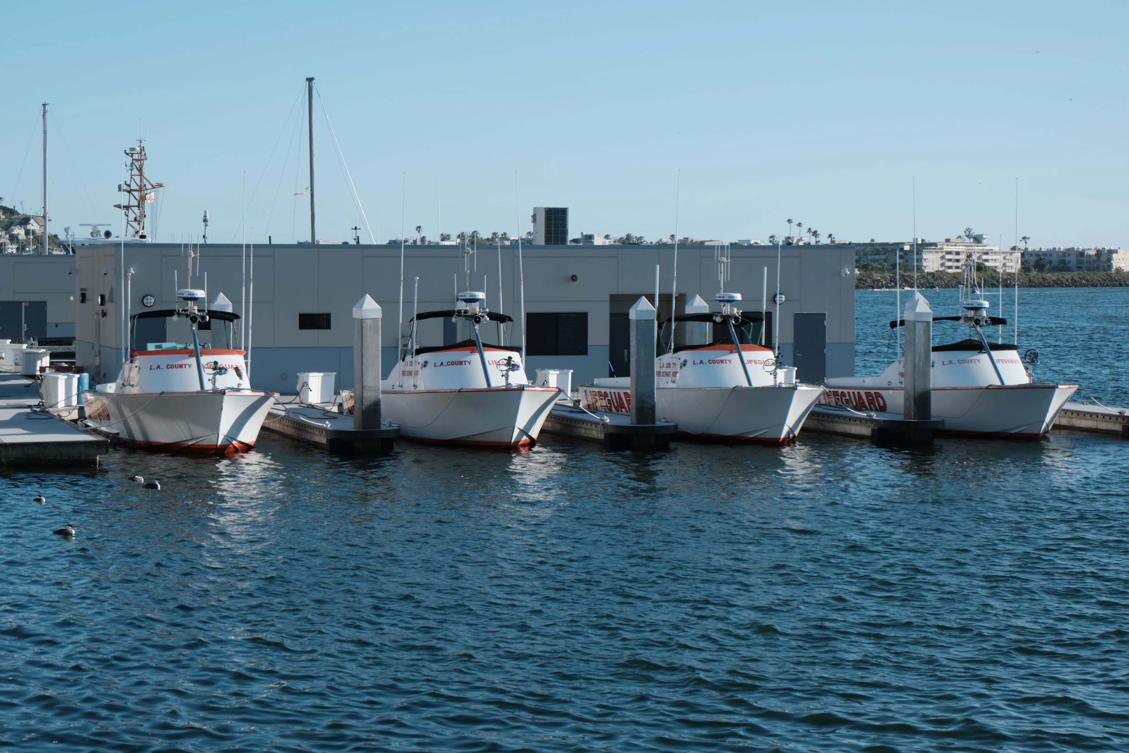 Small operational boats secured alongside a marina facility